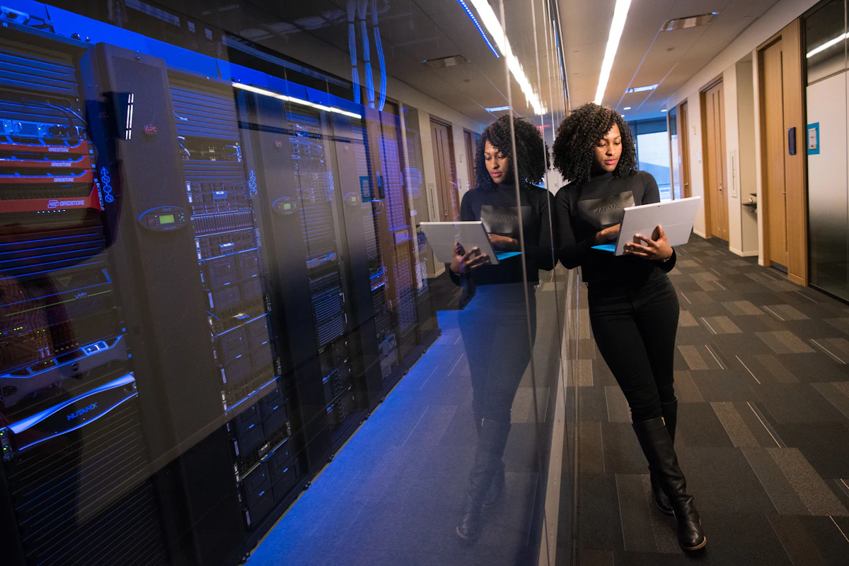 Engineers with tablets in a server room aisle